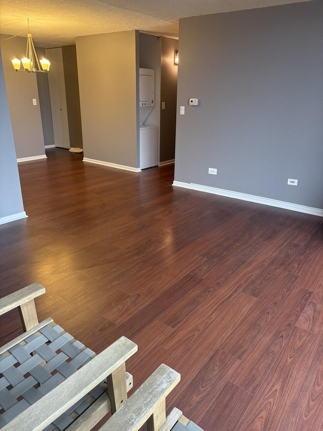 unfurnished living room with a notable chandelier and dark wood-type flooring