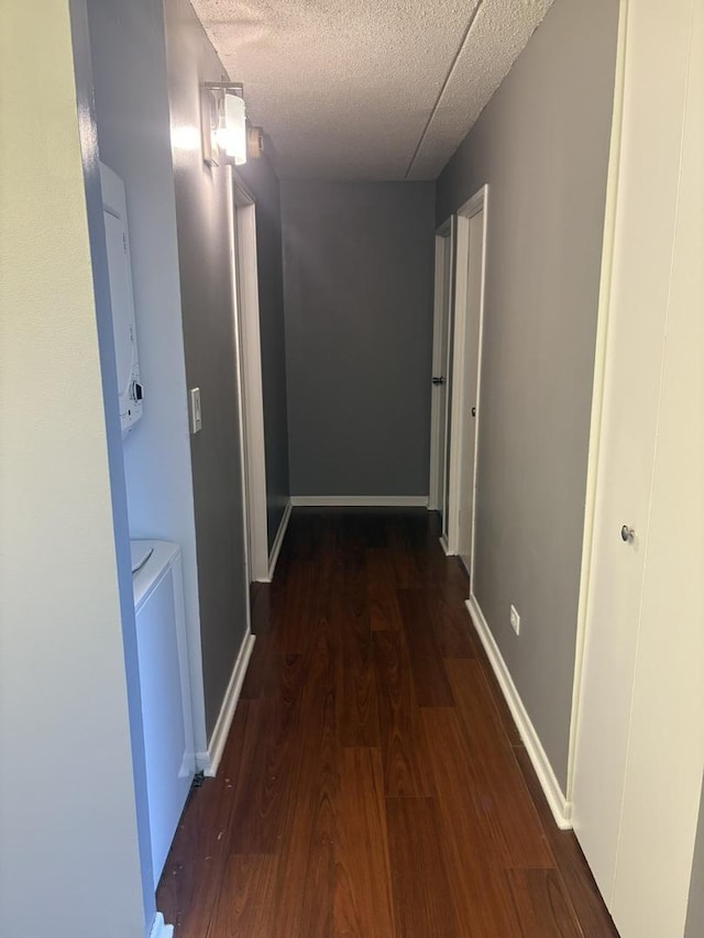 hallway with dark wood-type flooring and a textured ceiling