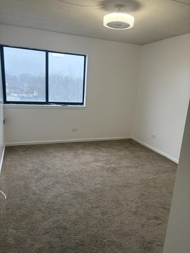 carpeted empty room with a textured ceiling