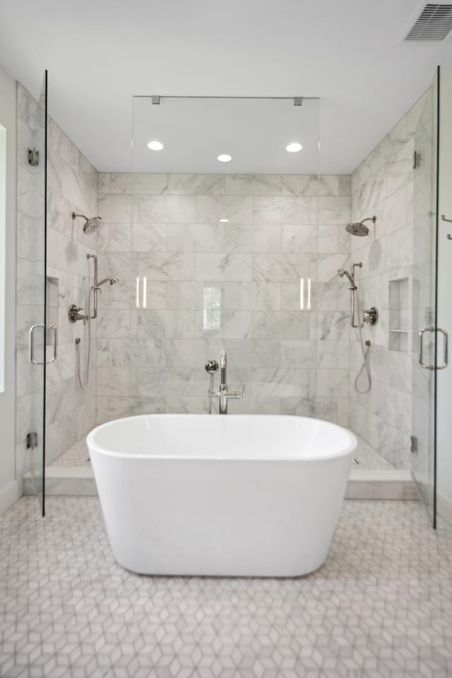 bathroom with tile patterned flooring and shower with separate bathtub