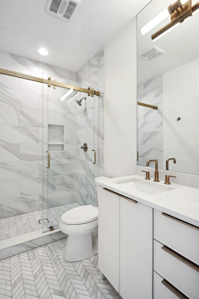 bathroom featuring tile patterned flooring, toilet, a shower with door, and vanity