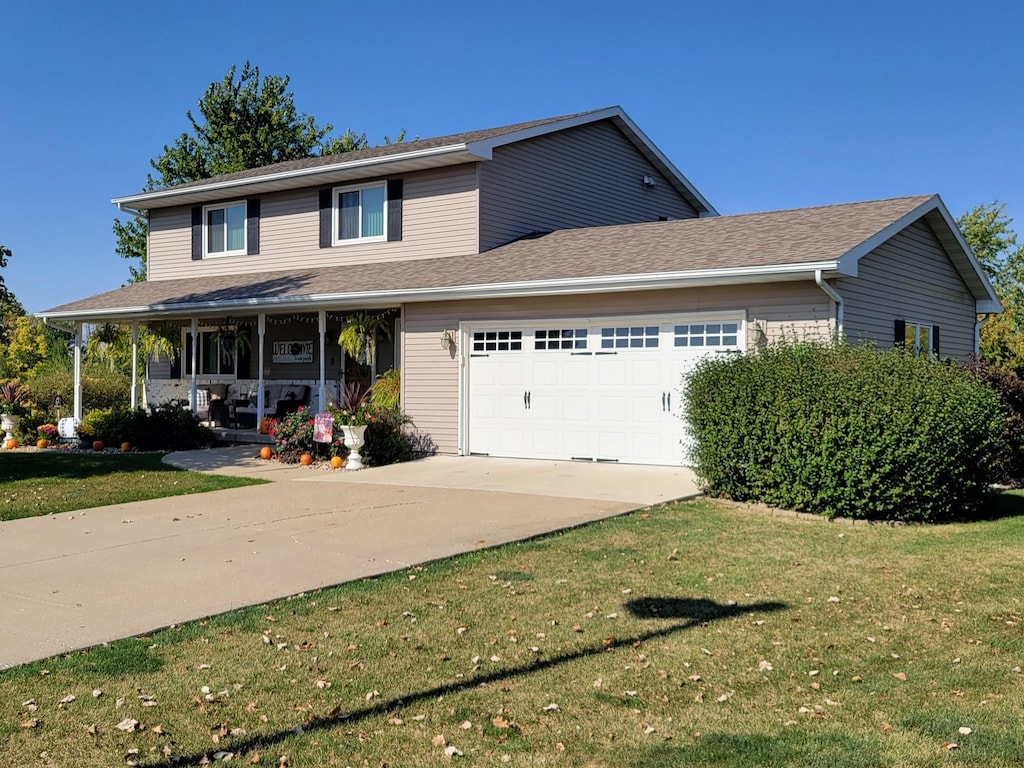 view of front facade with a garage, a front yard, and covered porch