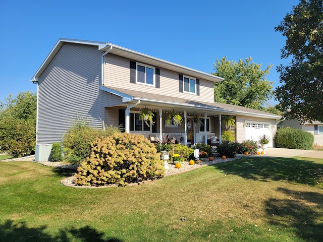 view of front of property featuring covered porch, a front yard, and a garage