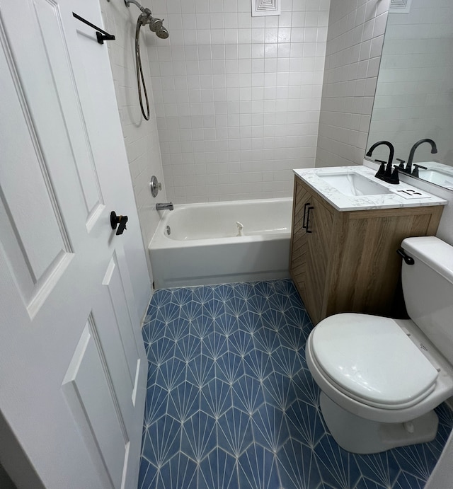 full bathroom with vanity, tile patterned floors, toilet, tile walls, and tiled shower / bath combo