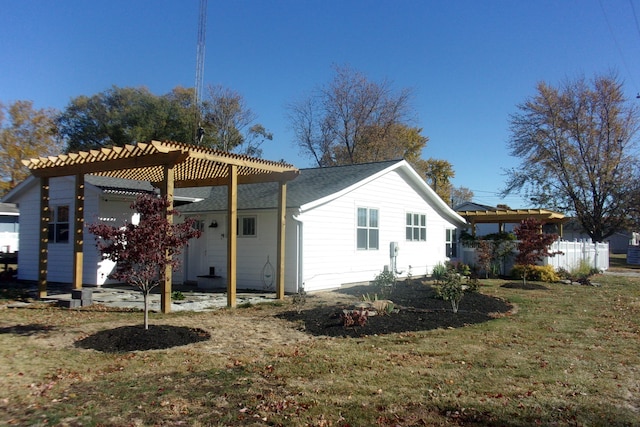 back of property with a yard and a pergola