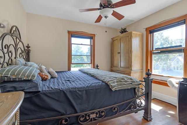 bedroom featuring light hardwood / wood-style floors, multiple windows, and ceiling fan