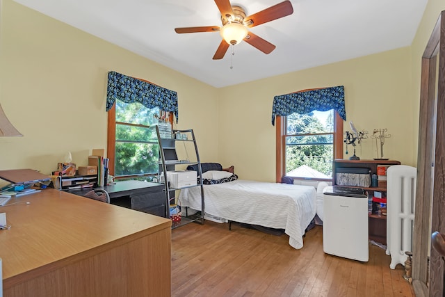 bedroom featuring light wood-type flooring, multiple windows, and ceiling fan