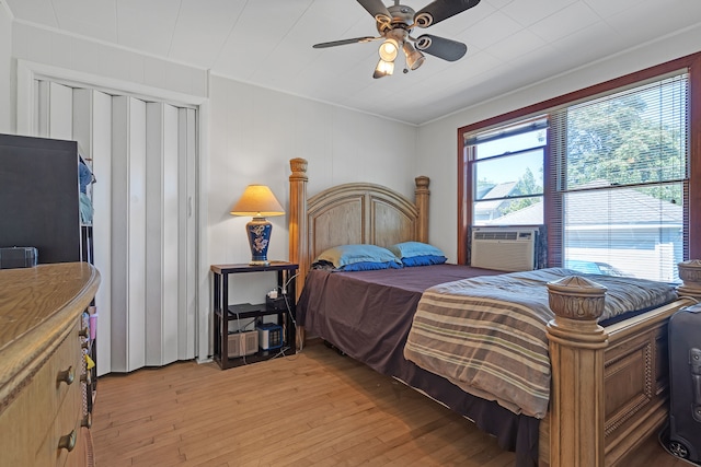 bedroom with ceiling fan, cooling unit, and light hardwood / wood-style flooring