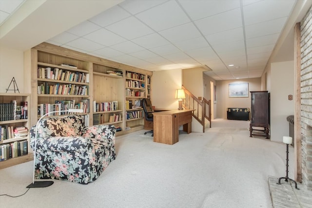 living area featuring a paneled ceiling, light carpet, and built in features