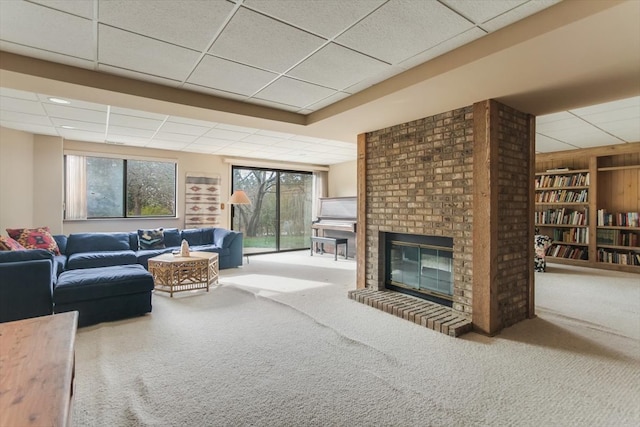 carpeted living room featuring a paneled ceiling and a fireplace