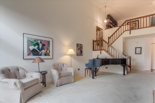 living area with carpet and a towering ceiling