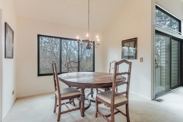 dining area with a chandelier, a wealth of natural light, and light carpet