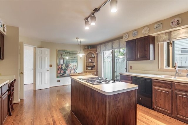 kitchen featuring stainless steel gas stovetop, dishwasher, sink, light hardwood / wood-style floors, and a kitchen island