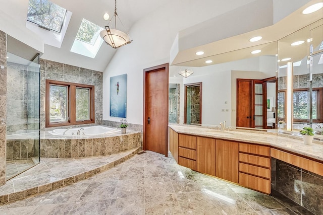 bathroom featuring plus walk in shower, vanity, a skylight, and high vaulted ceiling