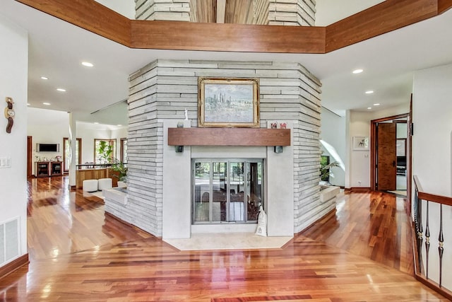 interior space with a towering ceiling and hardwood / wood-style flooring