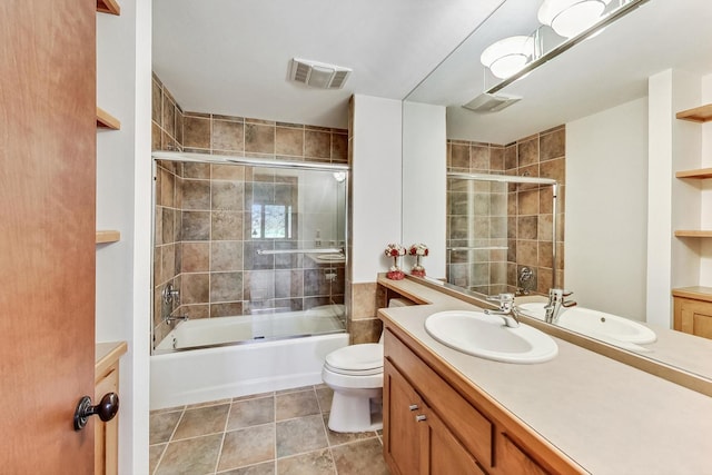 full bathroom featuring shower / bath combination with glass door, tile patterned flooring, vanity, and toilet