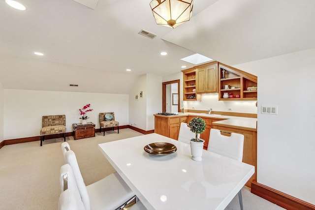 carpeted dining space featuring sink and lofted ceiling