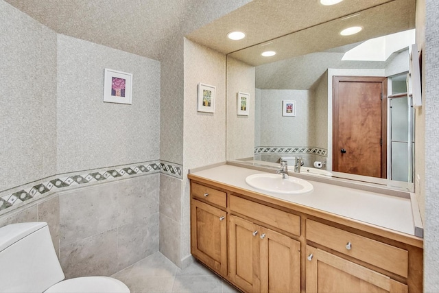 bathroom with tile patterned flooring, vanity, and toilet