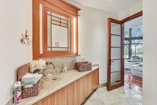 bathroom featuring hardwood / wood-style floors, vanity, and tasteful backsplash