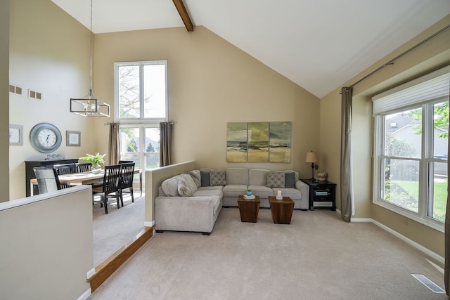 carpeted living room featuring an inviting chandelier, beamed ceiling, high vaulted ceiling, and plenty of natural light