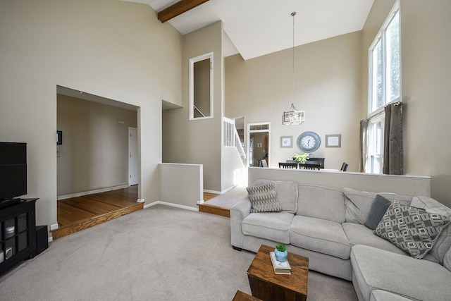 carpeted living room with beam ceiling, a chandelier, and high vaulted ceiling