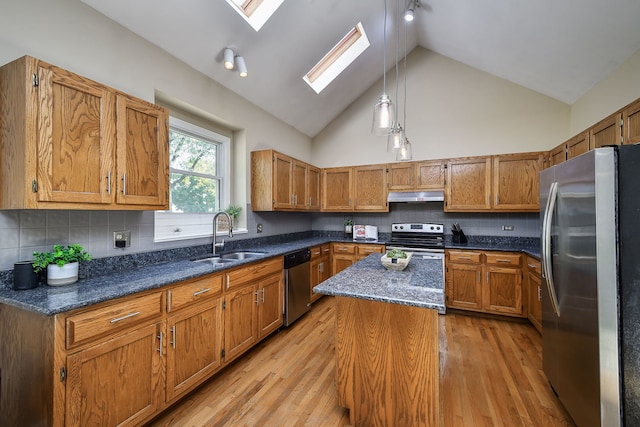 kitchen featuring appliances with stainless steel finishes, sink, backsplash, light hardwood / wood-style floors, and high vaulted ceiling