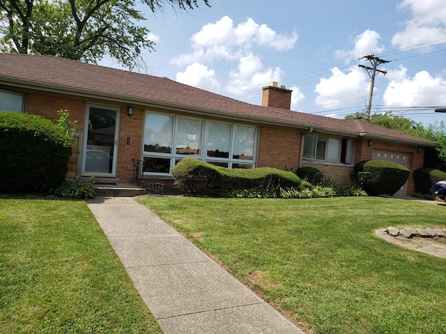 ranch-style home featuring a front lawn and a garage