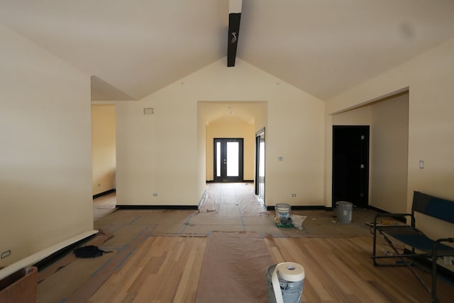 interior space featuring lofted ceiling with beams and light hardwood / wood-style flooring