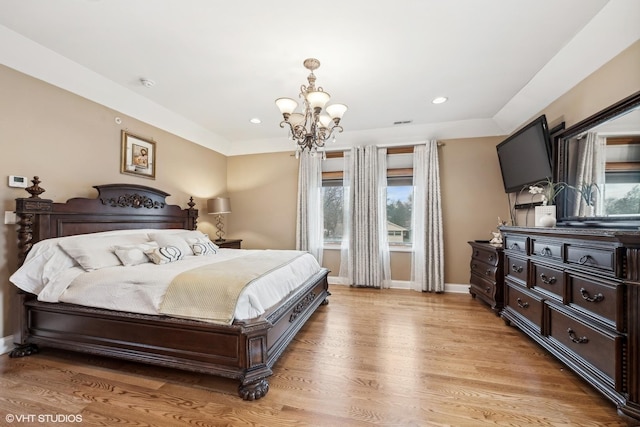 bedroom with light wood-type flooring and an inviting chandelier