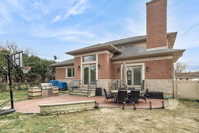 rear view of property with a yard, an outdoor kitchen, and a patio