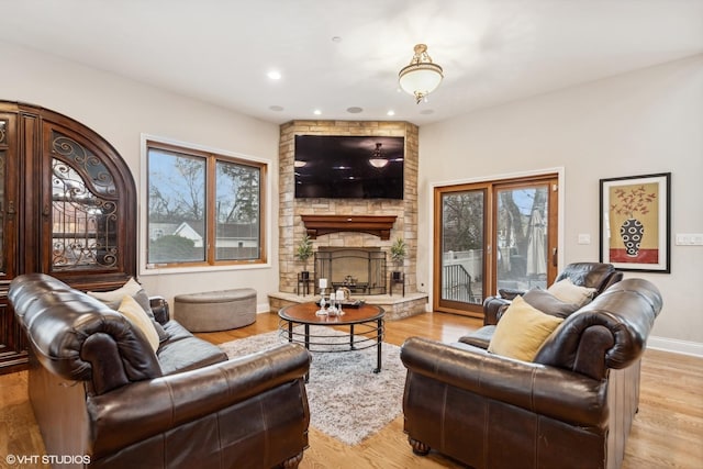 living room featuring light hardwood / wood-style floors and a stone fireplace