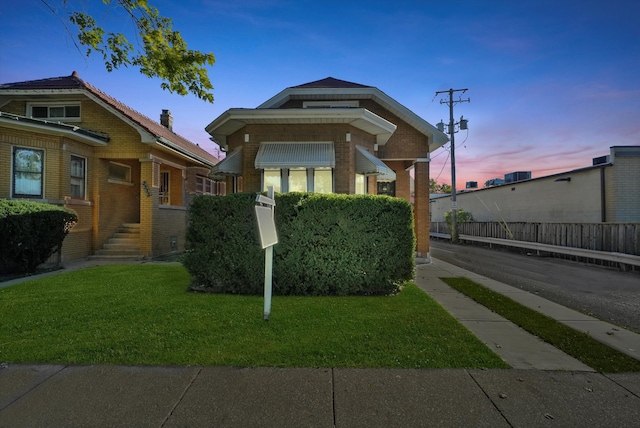 bungalow-style home with a yard