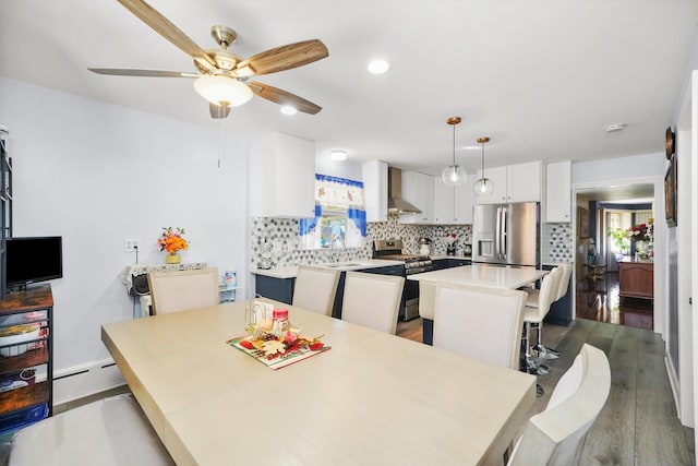 dining space with ceiling fan, sink, a baseboard radiator, and dark hardwood / wood-style flooring