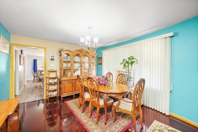 dining room with dark hardwood / wood-style flooring and a chandelier