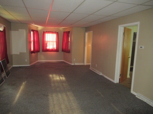 carpeted spare room with a drop ceiling