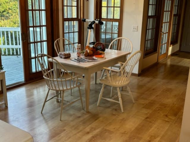 dining area with french doors and light hardwood / wood-style flooring