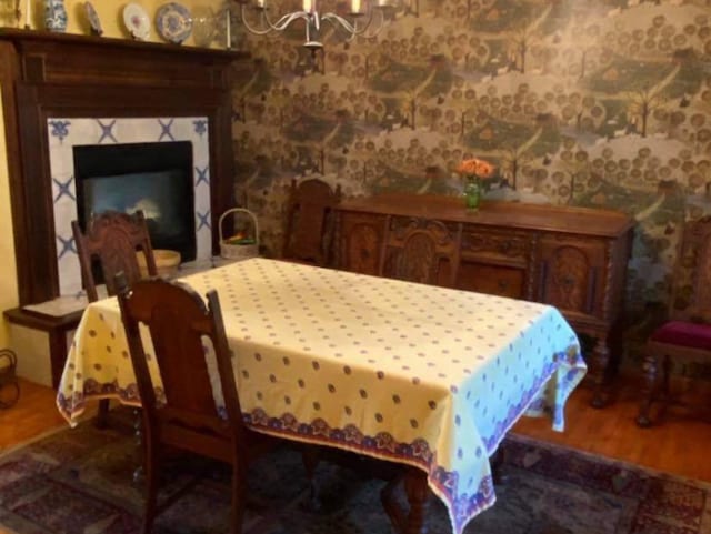 dining area with wood-type flooring and a notable chandelier