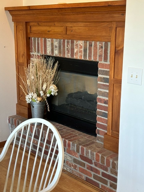 room details with a brick fireplace and hardwood / wood-style floors