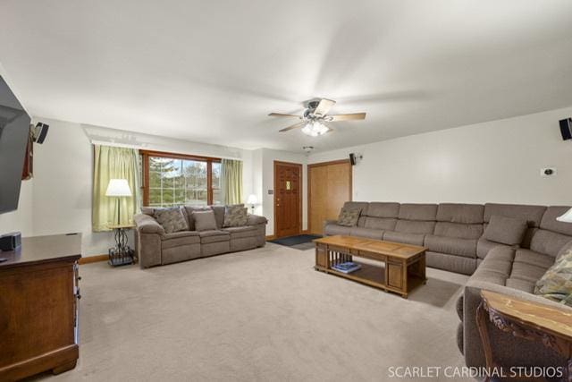 carpeted living room with ceiling fan