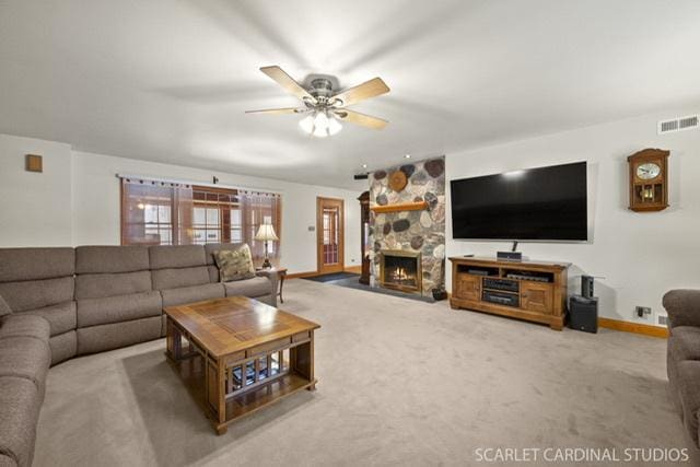 carpeted living room with ceiling fan and a fireplace