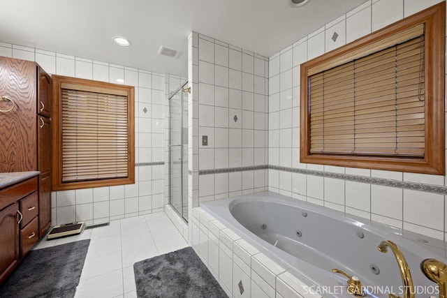 bathroom featuring tile patterned floors, vanity, tile walls, and independent shower and bath