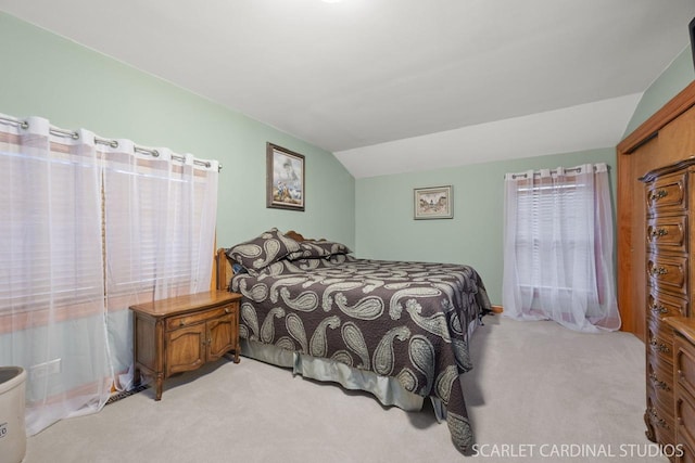 bedroom featuring light colored carpet and vaulted ceiling