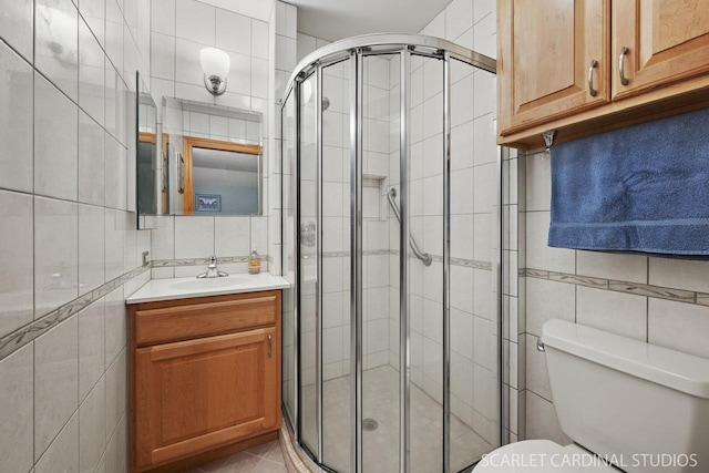 bathroom featuring vanity, an enclosed shower, tile walls, and toilet