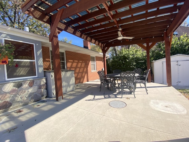 view of patio / terrace featuring a pergola, ceiling fan, and a storage unit