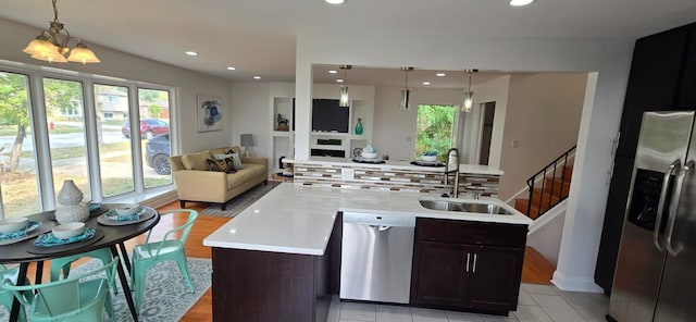 kitchen featuring dark brown cabinets, pendant lighting, stainless steel appliances, and sink