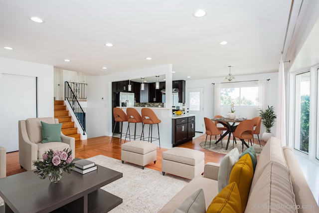 living room featuring light wood-type flooring and a chandelier