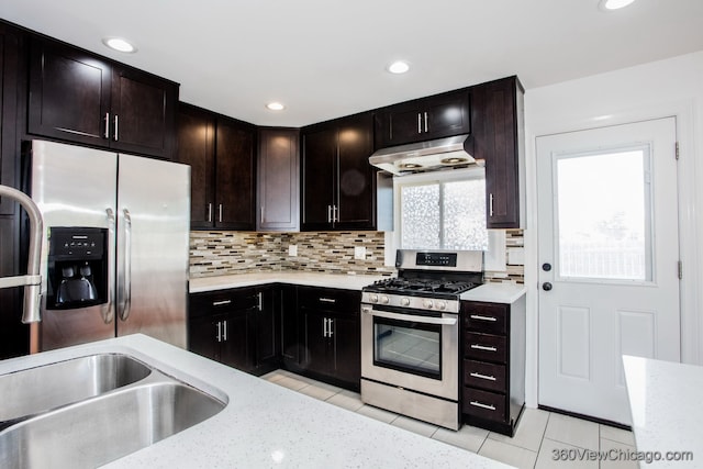 kitchen featuring dark brown cabinetry, stainless steel appliances, light tile patterned floors, and decorative backsplash