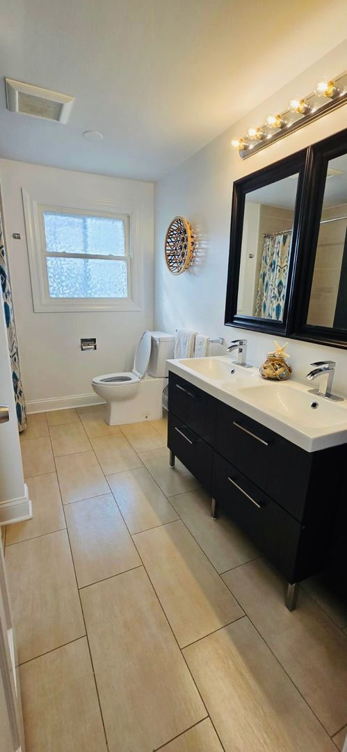 bathroom with vanity, toilet, and tile patterned floors