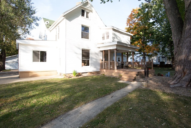 back of property with a porch and a lawn