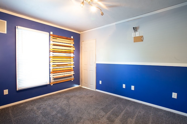 unfurnished room featuring crown molding and carpet